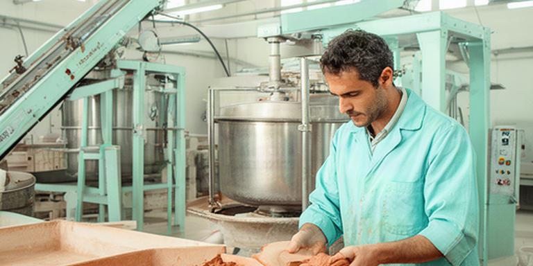 Operatore che controlla un impasto ceramico in uno stabilimento produttivo pugliese